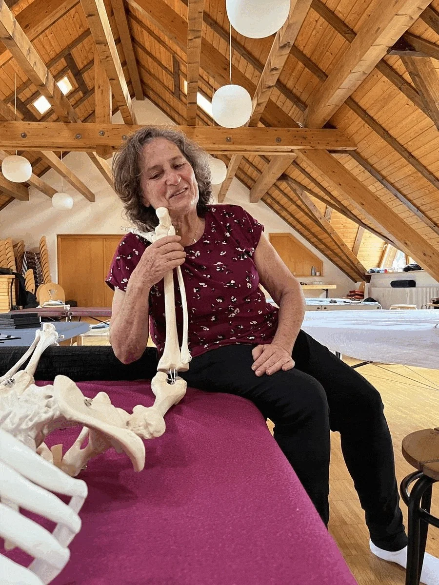 Yehudit Silver holding a bone from a skeleton while teaching